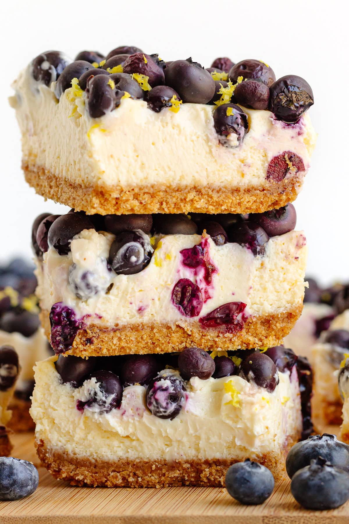A stack of blueberry lemon cheesecake bars.