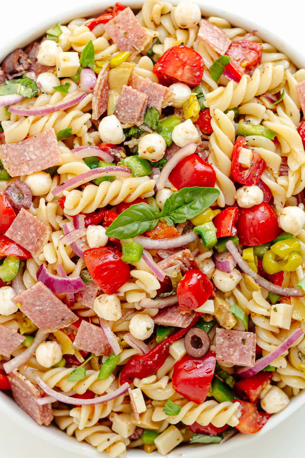 Antipasto pasta salad in a white serving bowl.