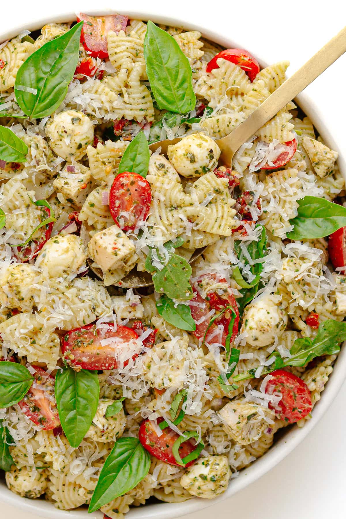 Chicken pasta salad with pesto vinaigrette in a serving bowl.