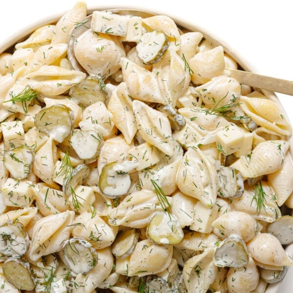 Dill pickle pasta salad in a serving bowl with serving spoon.