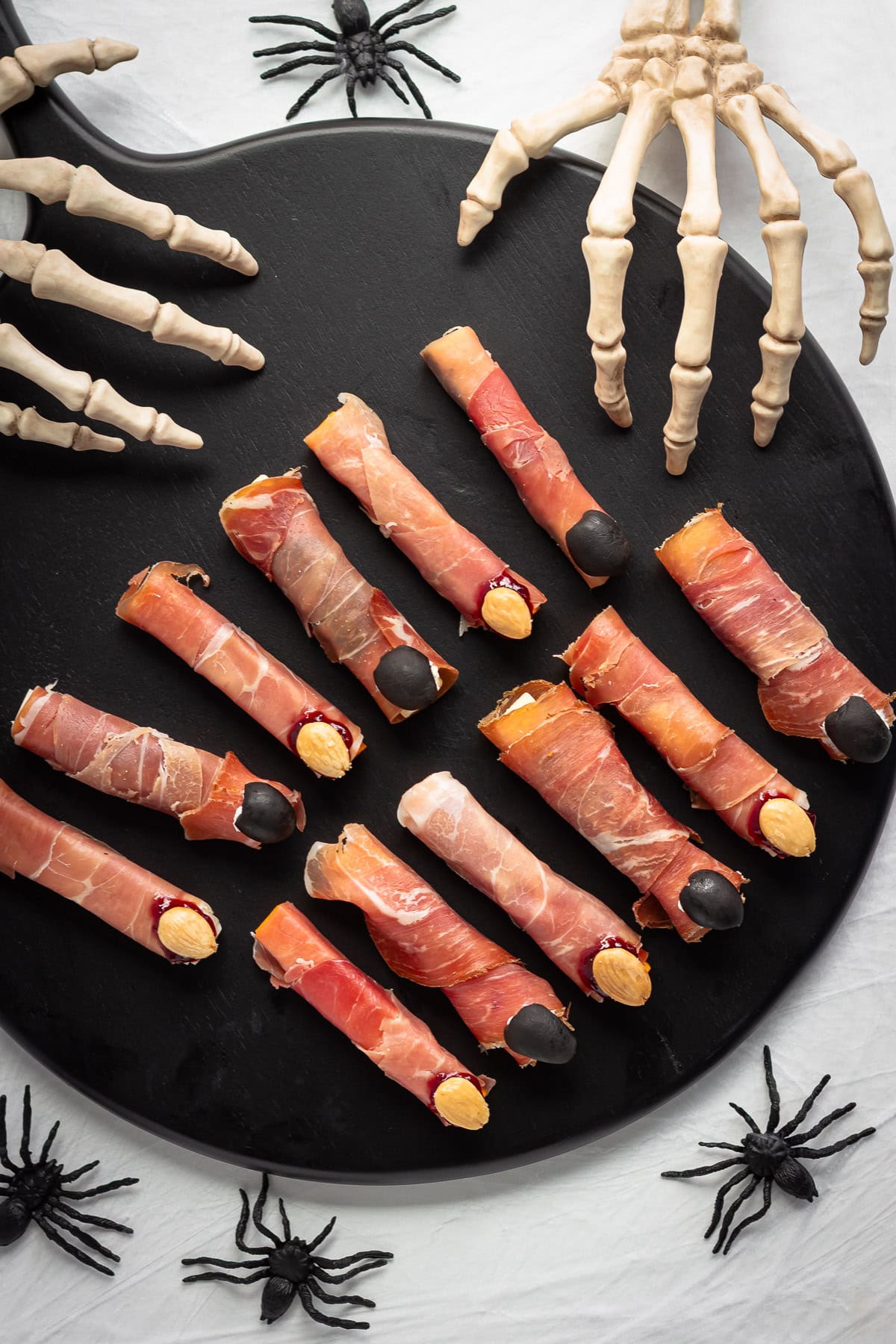 Halloween themed charcuterie witch fingers on a black serving board.