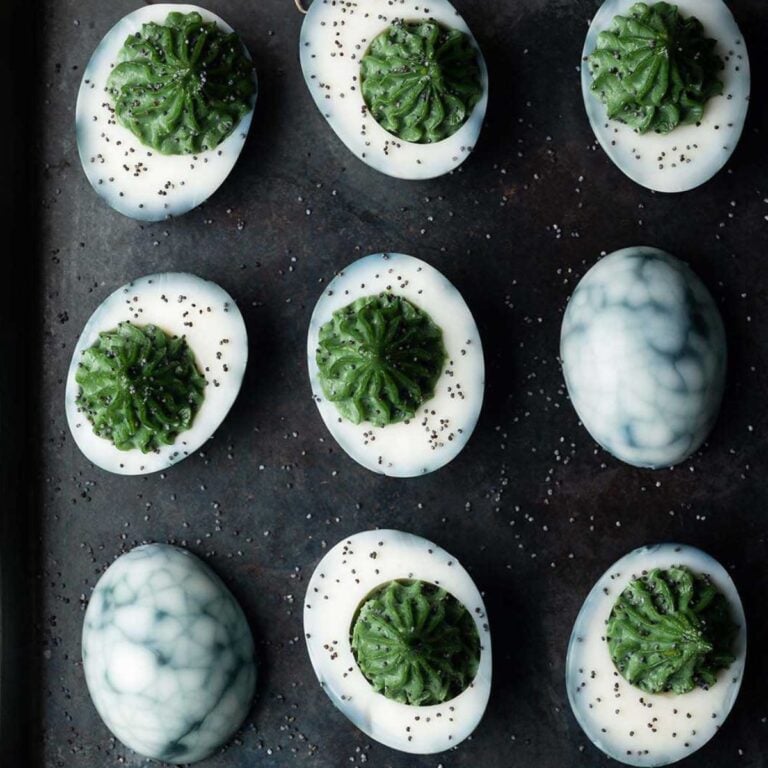 Halloween deviled eggs on a black surface.
