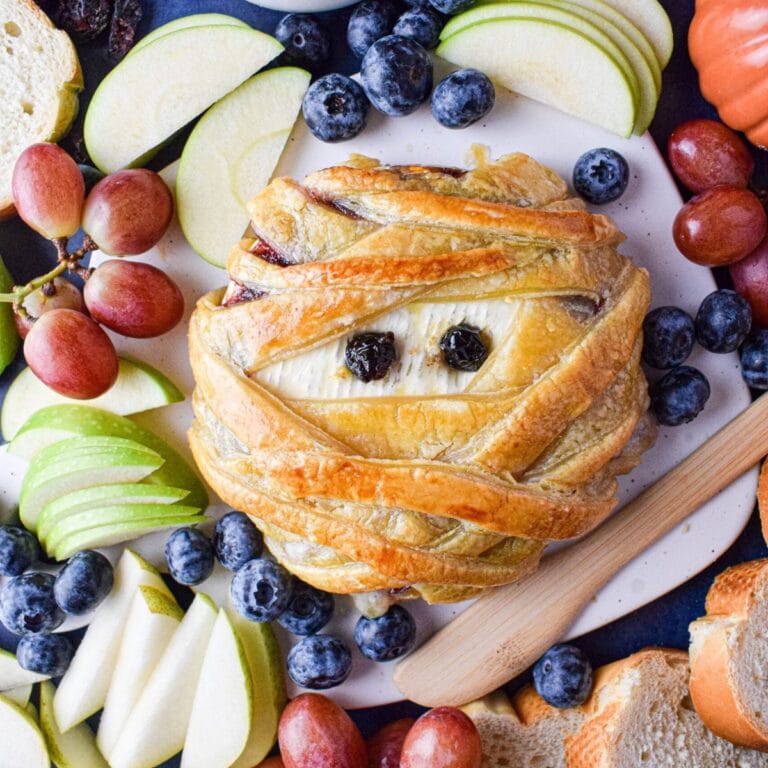 Brie cheese decorated with pastry to look like a Halloween mummy.