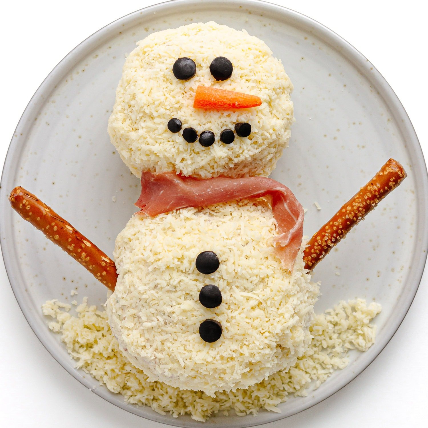 Finished snowman cheese ball on a plate.