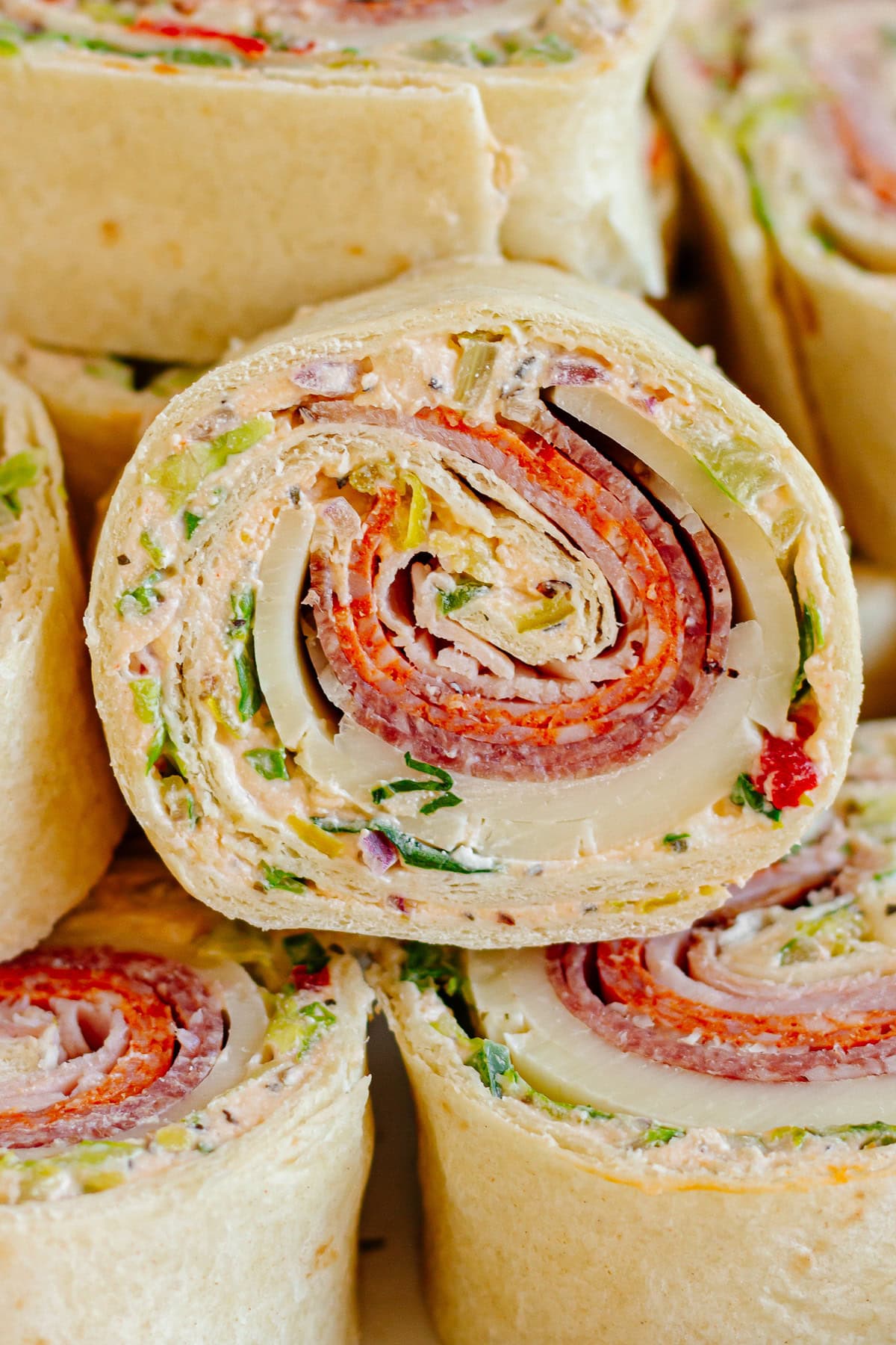 Closeup of an Italian pinwheel sandwich with cream cheese spread.