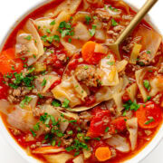 Bowl of cabbage and ground beef soup with a spoon.