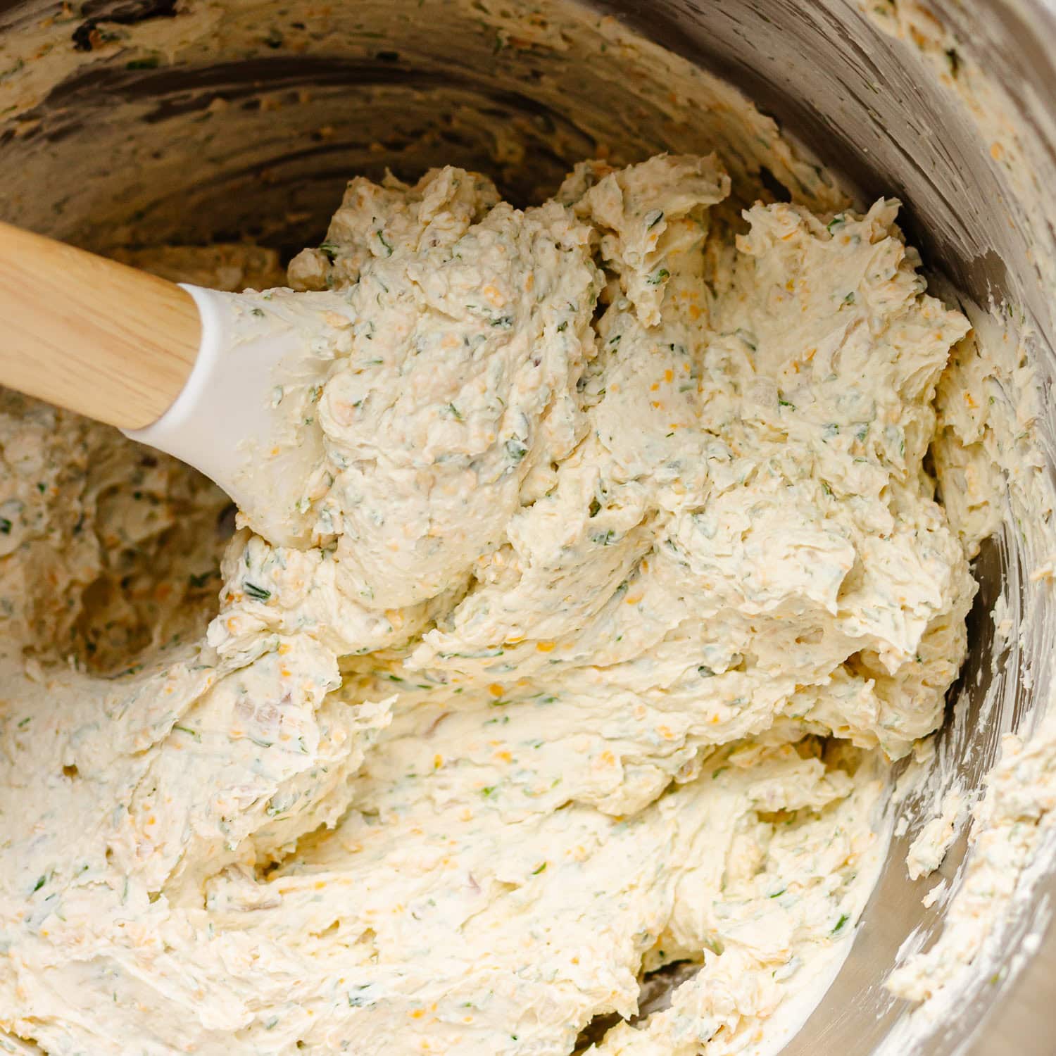 Spring flavored cheese ball mixture being mixed in a bowl.