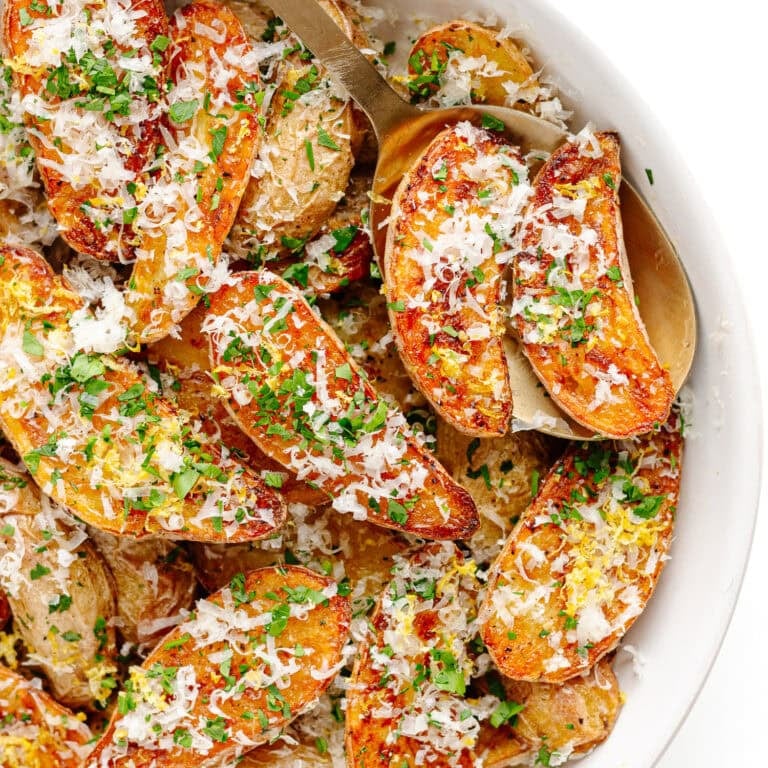 Parmesan truffle roasted fingerling potatoes in a white serving bowl.