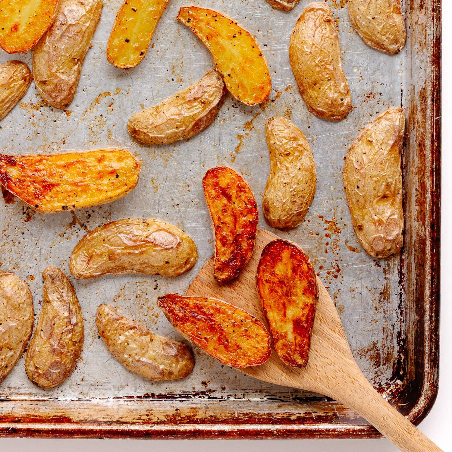 Roasted fingerling potatoes on a baking sheet.