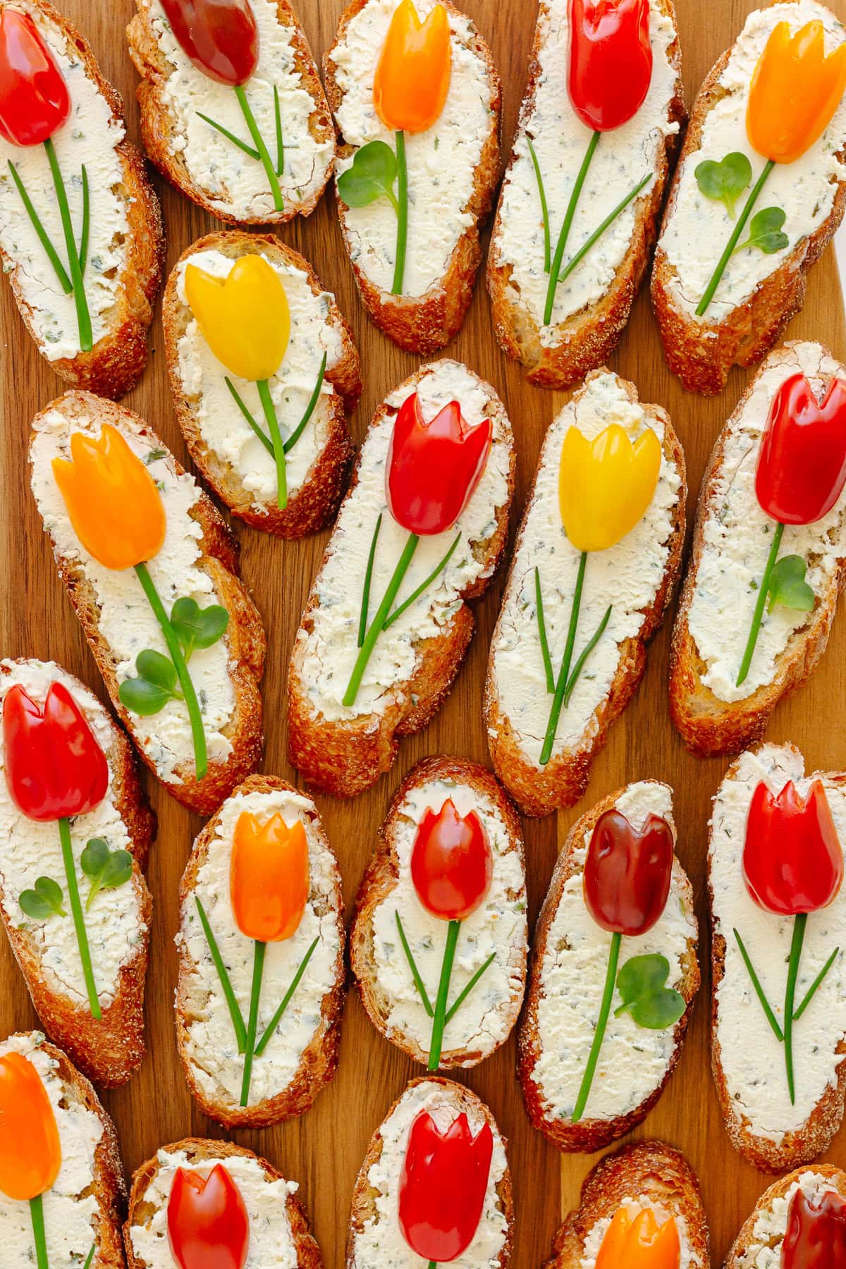 Spring tomato tulip crostini appetizer on a wood board.
