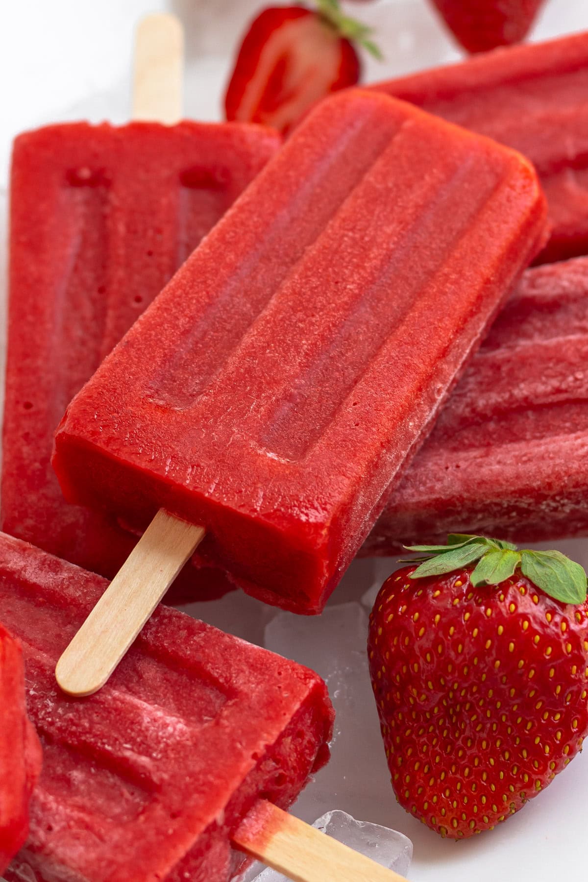 Pile of homemade strawberry popsicles.
