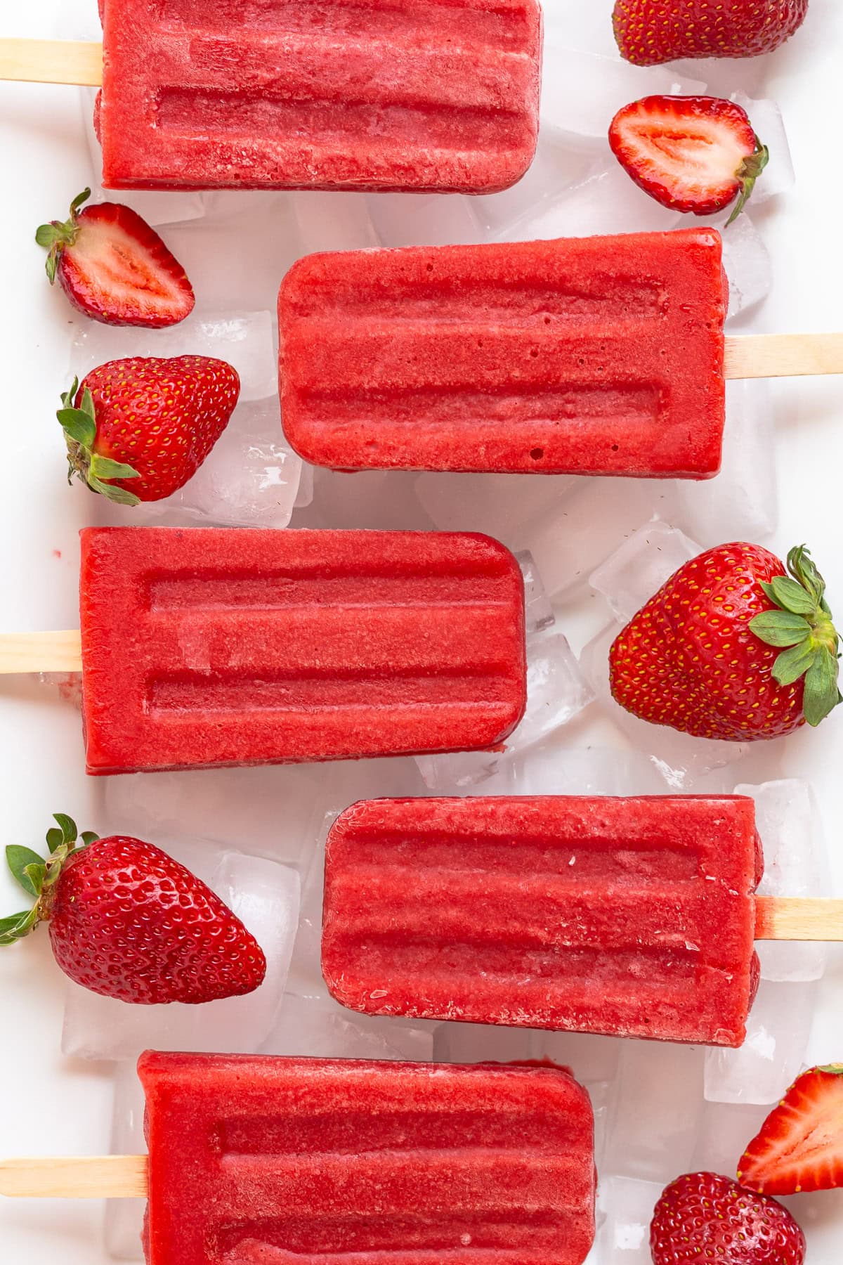 Strawberry popsicles on a platter of ice.