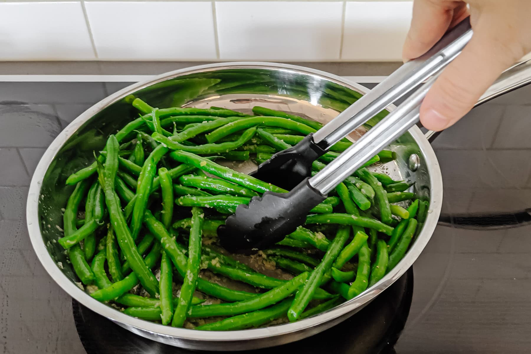 Green beans being sauteed in garlic butter.